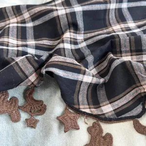 Nahaufnahme des schwarz-weißen Karierten Kopftuchs mit süßer brauner Stickerei.
