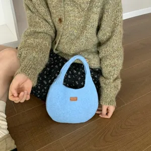 Detail shot of the soft blue knitted hobo handbag showcasing its plush texture and cozy style.