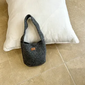 Detailed view of the dark grey felt hobo bag featuring a cozy texture and minimalist design.