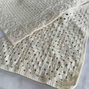Close-up van de beige gehaakte gebreide textuur, prachtig hol bloemenpatroon voor damesaccessoire.