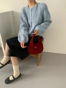 Detailed view of the soft fluffy knit handbag held by model, cozy autumn winter accessory.