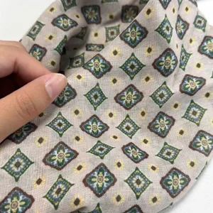 Close-up detail view of the retro printed silk scarf showing soft fabric and vintage geometric pattern.