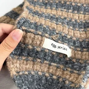Nahaufnahme der koreanischen gestreiften Plüsch-Ohrenschützer mit weicher Strickstruktur.