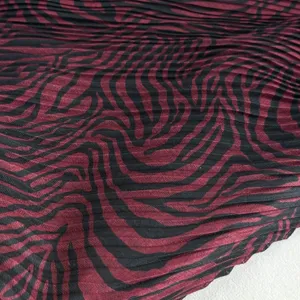 Close-up detail of retro pleated headscarf fabric showing unique black and red wavy texture.