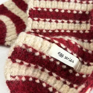Detaillierte Nahaufnahme der flauschigen rot weißen gestreiften Winter Ohrenschützer Textur.