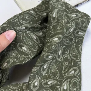 Dark green paisley pattern fabric detail, soft silk texture neck scarf close up view