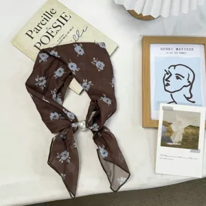 Brown floral small square silk scarf detail view with elegant pearl buckle accessory.