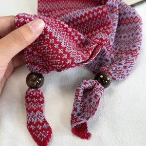 Primer plano detallado de una elegante bufanda de punto Fair Isle con cuentas oscuras.
