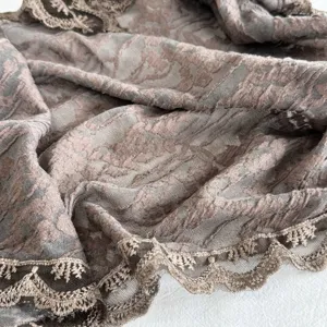 Detailansicht von stilvollem, strukturiertem Stoffaccessoire mit eleganter Spitzenborte.