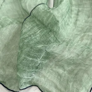 Λεπτομέλεια από λεπτό ανοιχτό πράσινο λινό φουλάρι υφής, κομψό old money γυναικείο.