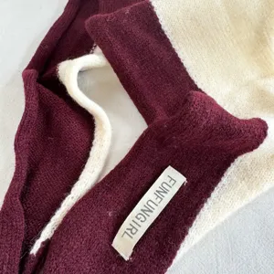 Color-block knit scarf detail showing soft textured fabric and contrast design for cozy winter warmth.