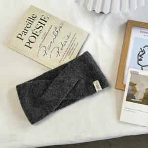Dark grey knitted twist headband for women, thick wool hair band, cozy winter hair accessory.