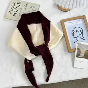 Detail view of the stylish colorblock knit scarf, cozy wine red and beige triangle wrap.