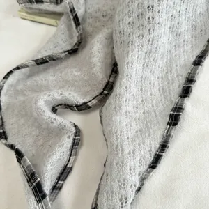 Pañuelo triangular de punto calado vintage con detalle de borde de cuadros blanco y negro.