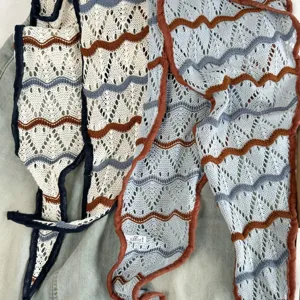 Nahaufnahme des hohlen Strick-Dreieckscharfs mit bunten Wellenmustern und feinen Rändern.