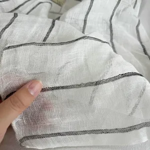 Detailed view of white striped linen gauze scarf fabric, lightweight sheer texture for women's wear.