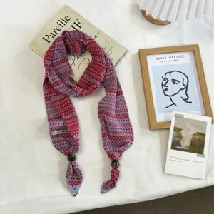 Bufanda estrecha de punto Fair Isle con patrones rojos y elegantes cuentas de madera en puntas.