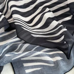 Close-up of lightweight black and white striped scarf fabric showing soft texture and fine edges.