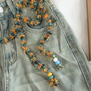 Gedetailleerde close-up van de kleurrijke pluizige garen ketting en vintage riem.