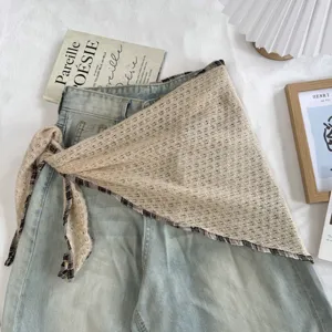 Vista detallada de pañuelo triangular calado vintage, accesorio de moda estival.