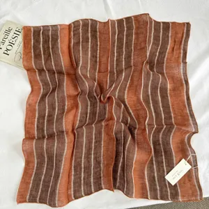 Detail view of the retro orange striped linen square scarf showing soft texture and close-up.