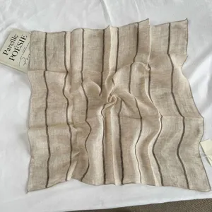 Close-up detail of vintage striped linen square scarf, relaxed style, neutral tone, soft texture.