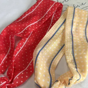 Detailed close-up of narrow long scarves featuring vibrant polka dot and stripe patterns for women.