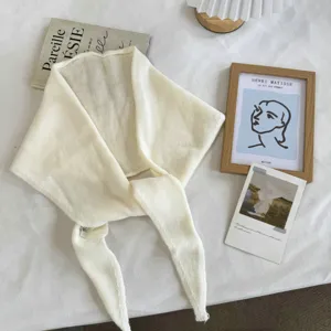 Detail view of a cream white knit hollow triangle scarf shawl, cozy neck warmer for autumn winter.