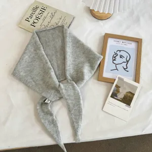 Close up detail of grey knitted triangular scarf, soft and warm neck warmer for daily wear.