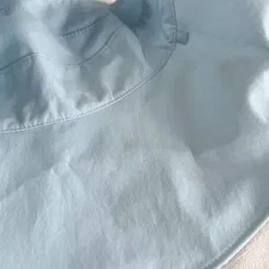 Light blue sun hat detail shot, stylish brim and fine stitching, perfect for sunny days.