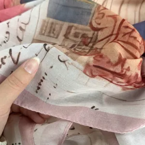 Artistic print silk scarf fabric detail close-up, soft texture and elegant border.