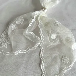 White lace neck scarf with pearl detail, elegant floral embroidered accessory for women.