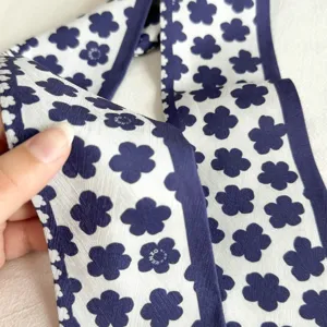 Vue détaillée de l'élégant foulard en soie long à motif floral bleu et blanc pour femmes.
