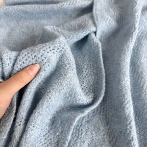 Gros plan sur un tissu en maille bleu clair doux montrant une texture confortable pour foulard.