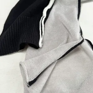 Knitted leg warmers detail shot showing soft texture, black and white split style knitwear.