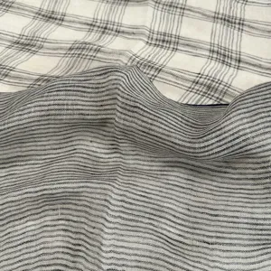 Vue détaillée de l'écharpe en lin doux avec un motif classique à rayures et carreaux noir et blanc.