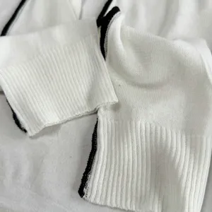 Minimalist solid color knitted leg warmers detail, white with black trim summer style.