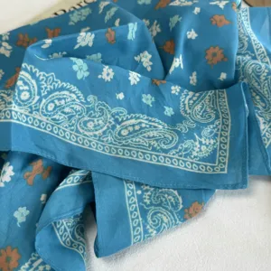 Blue cotton bandana scarf with paisley border and floral print, stylish summer accessory.