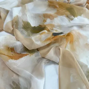 Sciarpa in seta con stampa artistica leggera in primo piano, dettagli di tessuto e orlo.