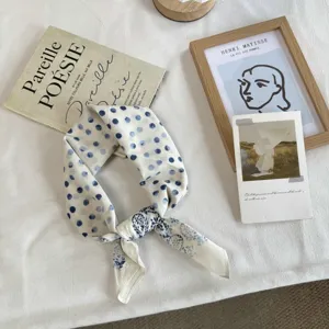 Detailopname van de elegante blauwe stippen zijden sjaal met zachte stof en knoop.