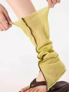 Close-up detail of knitted split leg warmers with stylish contrast trim for women.