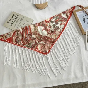 Detailed view of retro paisley print triangular scarf with white fringe, ethnic style boho detail.