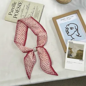 Gedetailleerd overzicht van vintage roze gestippelde zijden sjaal met elegante parelring.