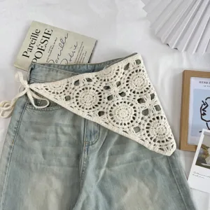 Gros plan détail de la ceinture triangle en crochet rétro superposée sur jean bleu.