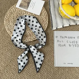 Detailansicht des schicken schwarz-weißen Polka-Dot-Schals, ideal für stylische Looks.