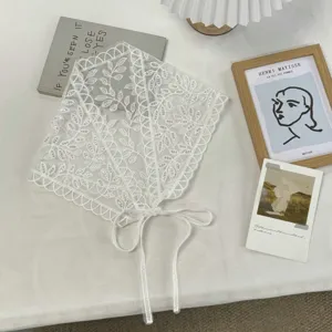 Detailed view of white lace triangle scarf tie apron pastoral chic photo prop accessory.