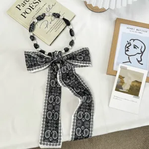 Élégant foulard ruban cachemire noir et blanc avec perles et nœud, accessoire de cheveux chic.