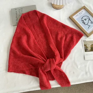 Vue détaillée du foulard triangulaire en tricot rouge avec texture douce et nœud.