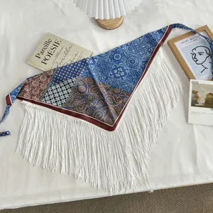 Detailed view of vintage ethnic print triangular scarf with white fringes and ties.