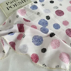 Detailed view of lightweight women's summer scarf with colorful polka dot print and lace edge.